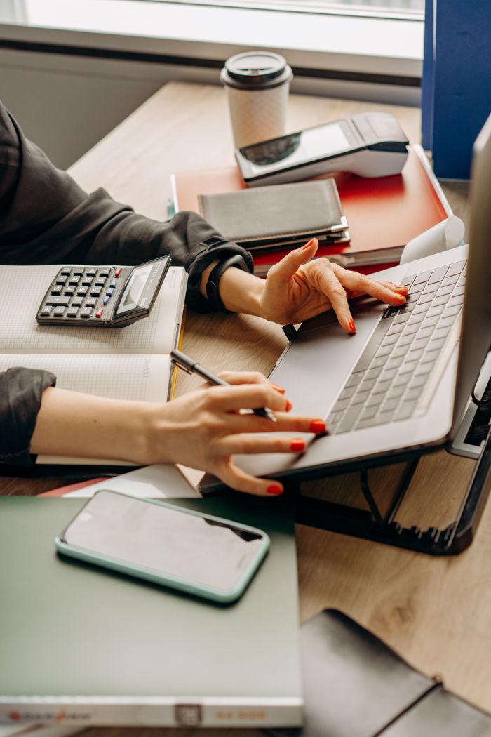 why-choose-us A tidy workspace with a laptop, gadgets, and office supplies on a wooden desk.